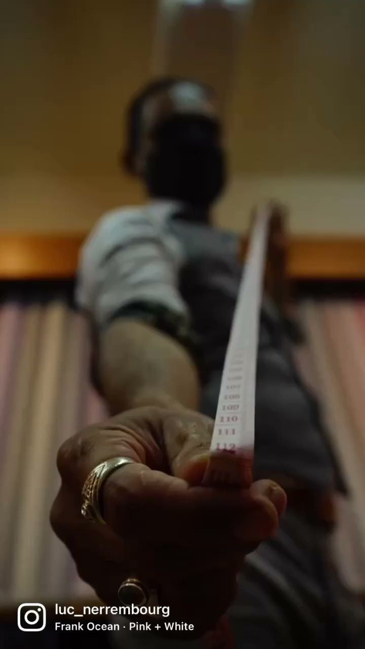 Lucky holding a tape measure at Keck Custom Tailor