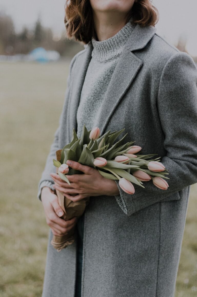 woman holding pink tulips wearing seasonal suits