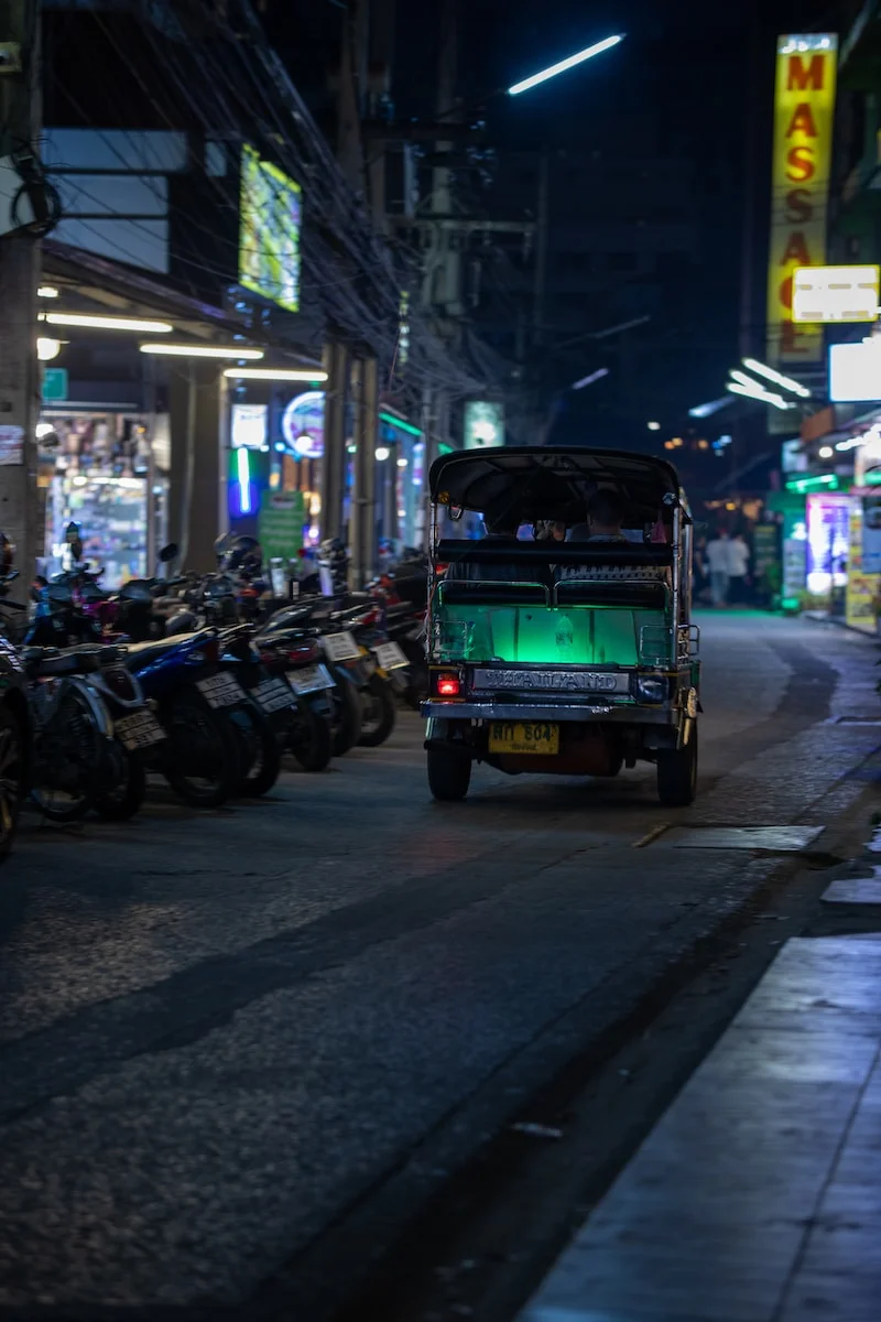 a truck driving down a street at night